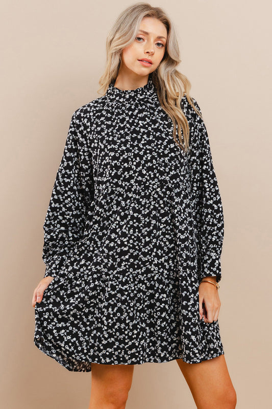 Woman wearing a black floral dress against a beige background