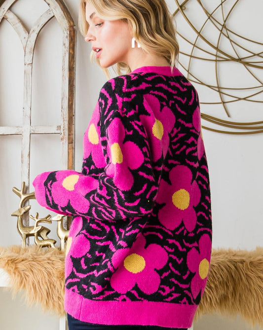 A woman wearing a vibrant sweater with pink floral patterns and black zebra stripes.