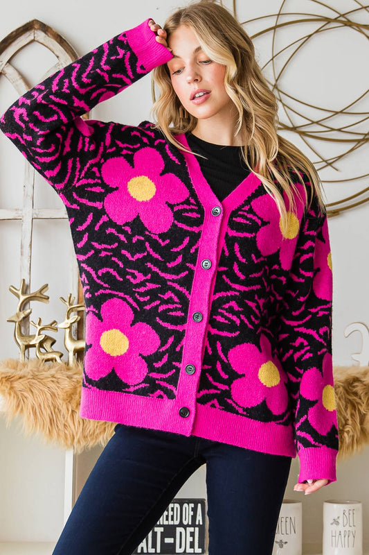 A woman wearing a hot pink flowered sweater, cardigan. 